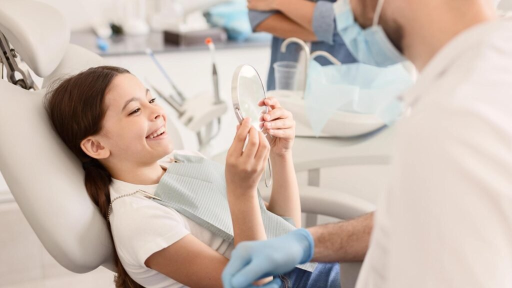 Jeune patiente souriante regardant son sourire dans un miroir après un traitement orthodontique dans une clinique dentaire moderne.