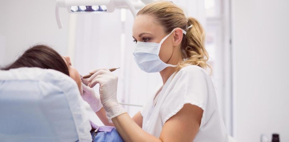 Dentiste prenant en charge une urgence dentaire lors d’un soin en cabinet avec équipement médical et instruments dentaires.