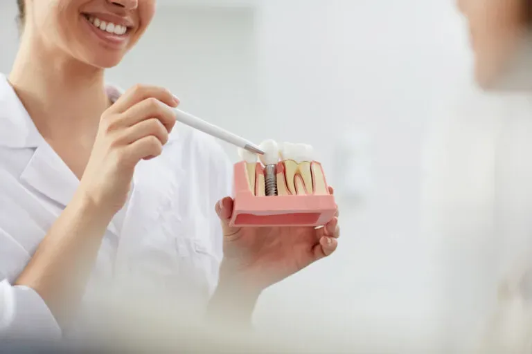 Dentiste expliquant un traitement Hollywood Smile avec facettes dentaires à une patiente dans un cabinet d’esthétique dentaire moderne.