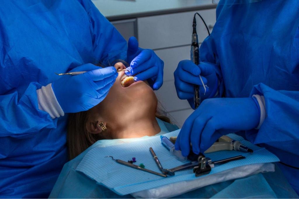 Intervention de chirurgie dentaire réalisée par une équipe médicale avec instruments spécialisés et soins opératoires en cabinet dentaire.