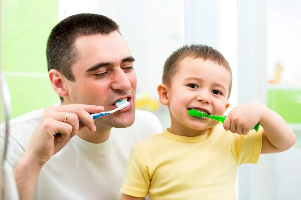 Père et son enfant se brossant les dents, une hygiène essentielle pendant un traitement par aligneurs